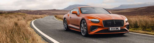 Una splendida Bentley Continental GT Speed di colore arancione acceso, che mette... Dual UHD