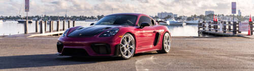 Un primo piano di una potente auto sportiva Porsche, che mette in risalto il suo... Dual UHD