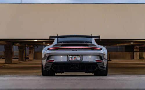 Un primo piano dettagliato di una Porsche 911 GT3 RS, un’auto sportiva ad alte prestazioni. 7680x4800