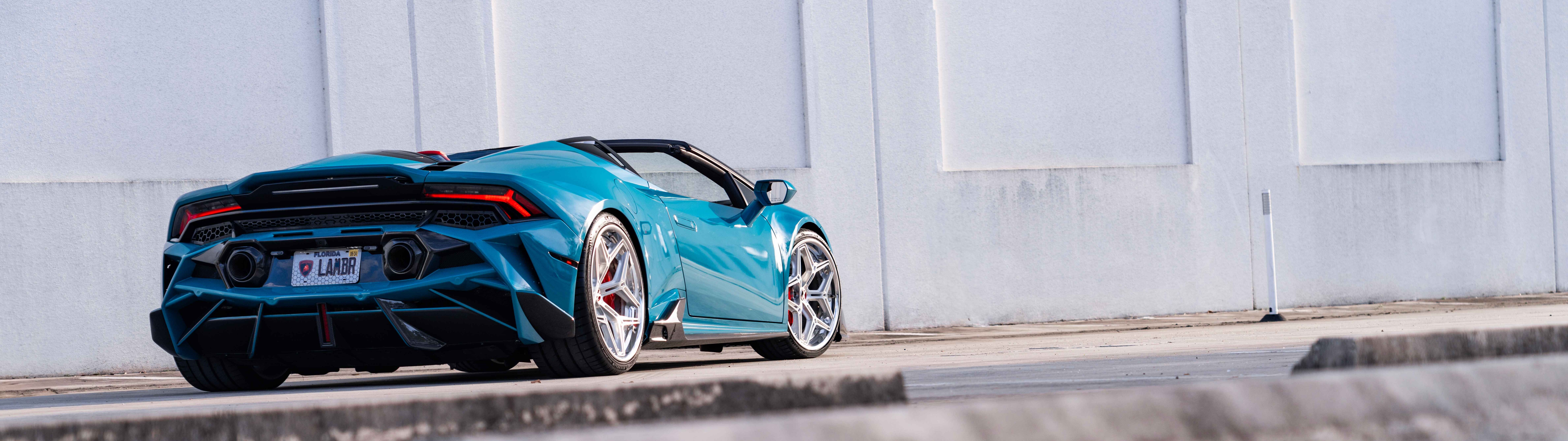 Una vista dettagliata di una Lamborghini Huracan Evo, che ne mette in risalto l’iconico design aerodinamico e la linea elegante tipica delle supercar.