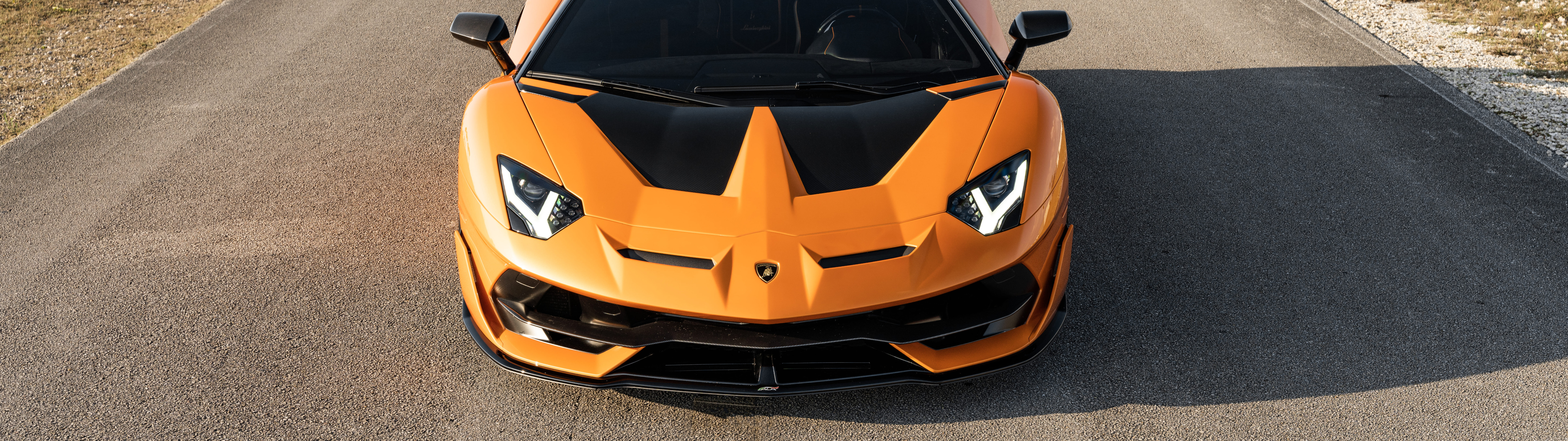 Una ripresa ravvicinata di una Lamborghini Aventador SVJ, che ne mette in risalto la linea aerodinamica e il design elegante, tipico di una supercar.