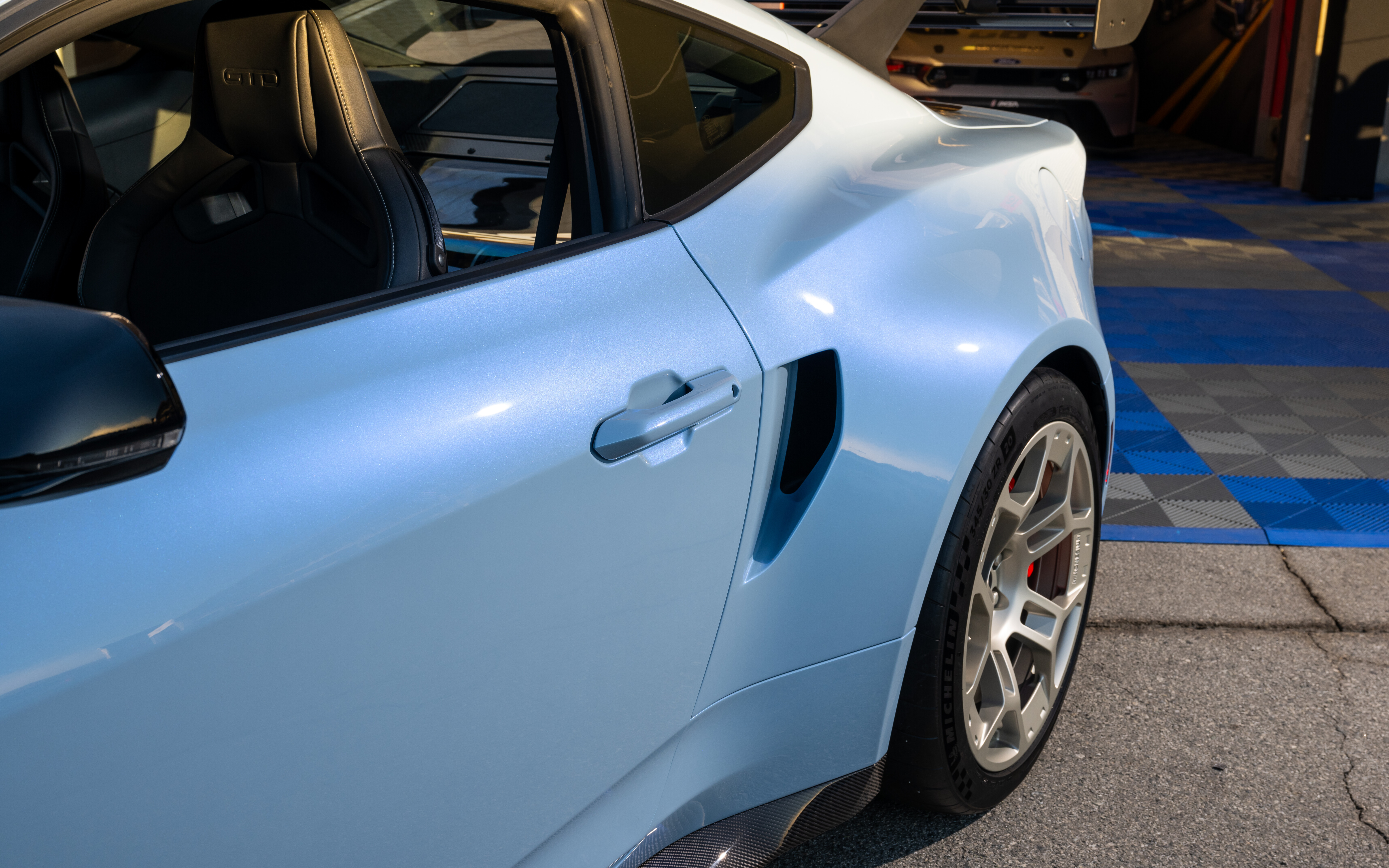 Una vista dettagliata della Ford Mustang GTD, che ne mette in risalto il design aerodinamico aggressivo e la carrozzeria allargata.