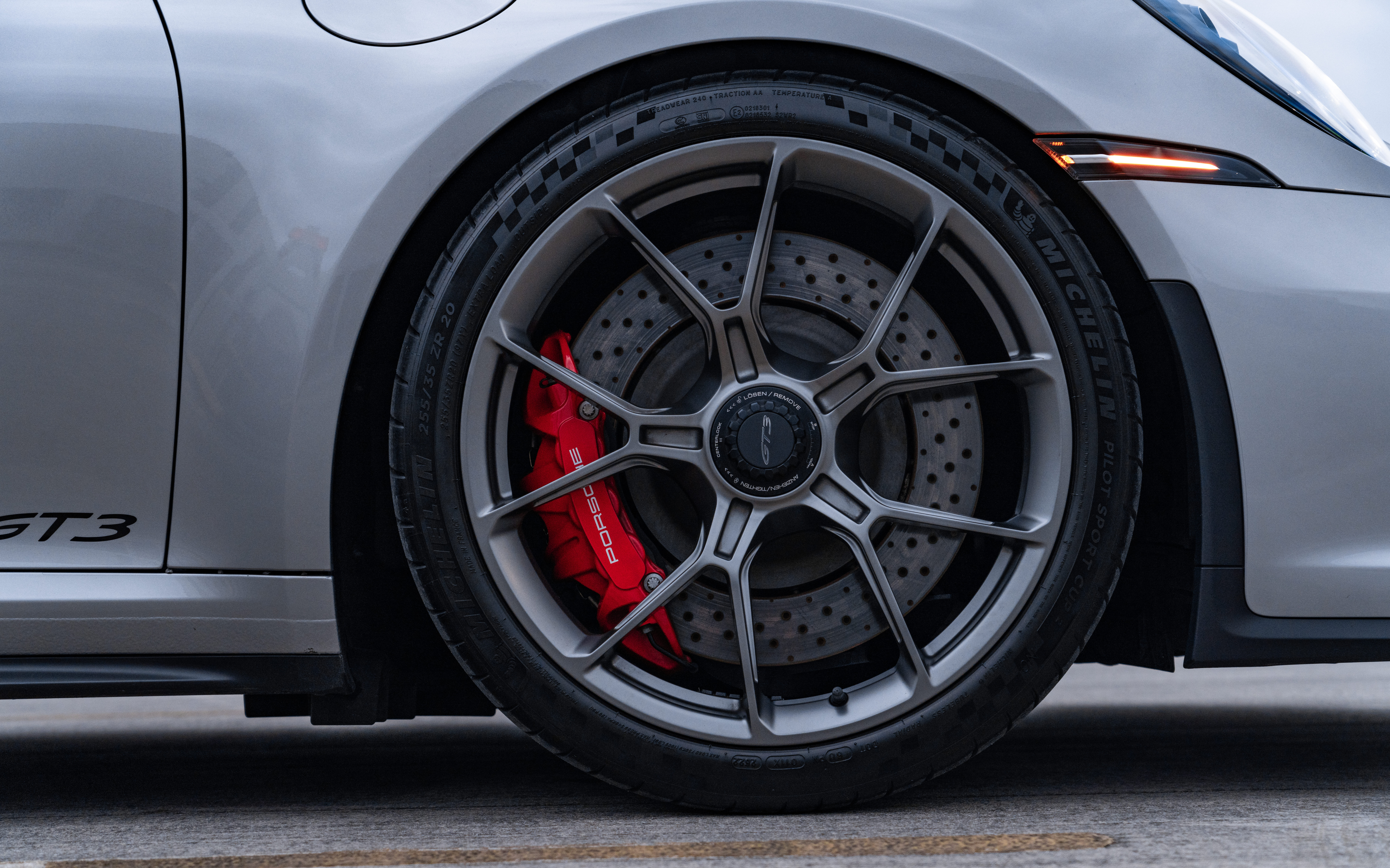 Una Porsche GT3 RS, un’auto sportiva ad alte prestazioni, caratterizzata da una carrozzeria aerodinamica e da un caratteristico alettone posteriore.