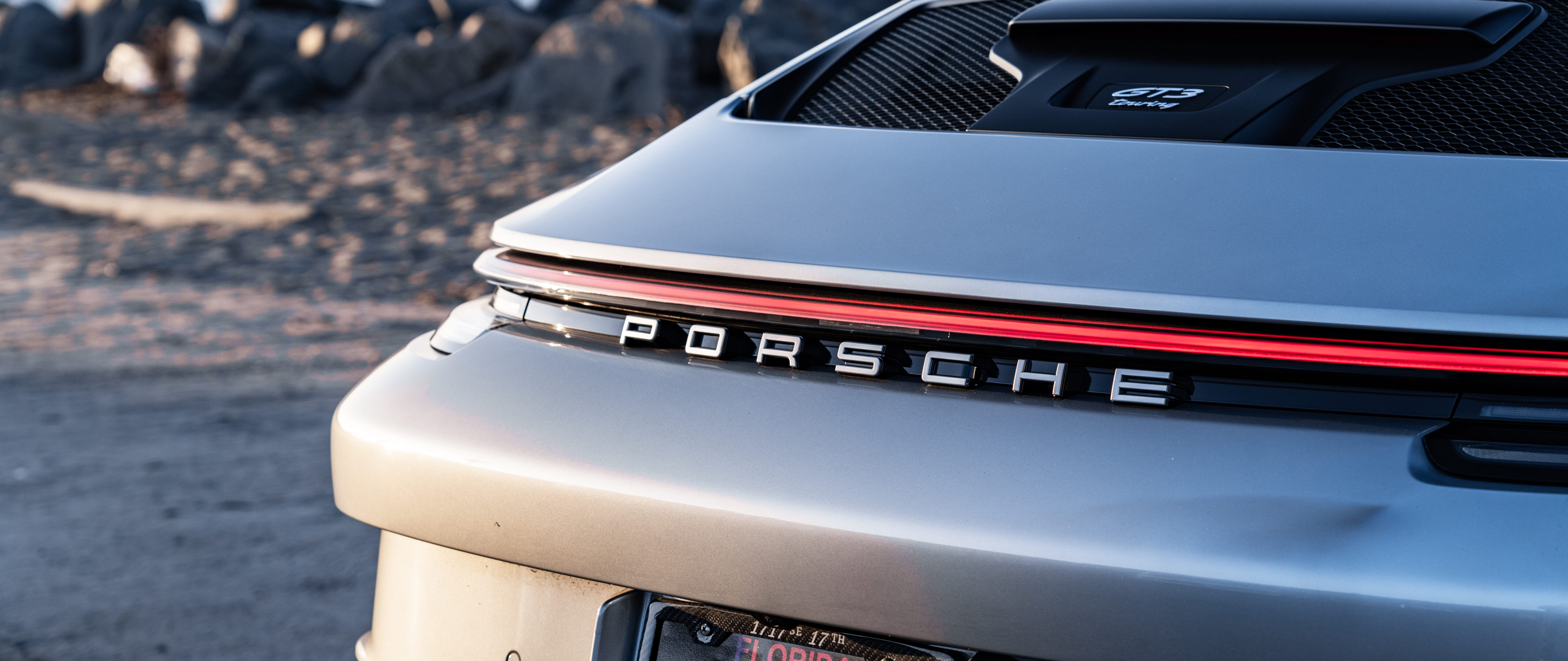 Una Porsche GT3 RS, un’auto sportiva ad alte prestazioni, caratterizzata da un design aerodinamico aggressivo e da una linea elegante e filante, tipica delle auto da corsa.